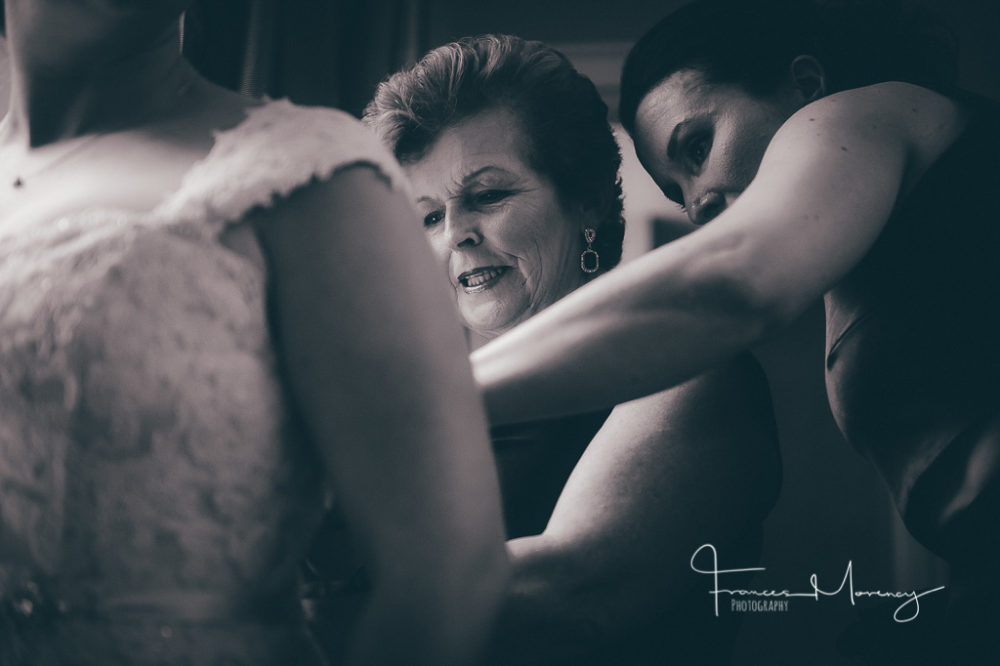 bride and her mom and maid of honour button up the back of her wedding gown. Collingwood Wedding Photographer-4703
