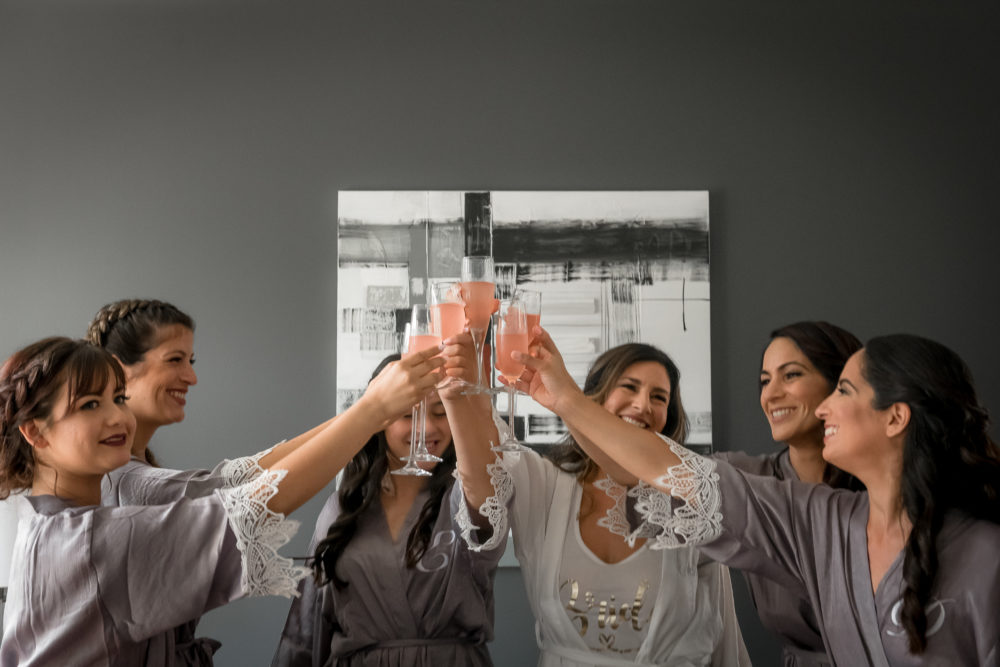 bridesmaids toast with pink champagne before getting into their dresses