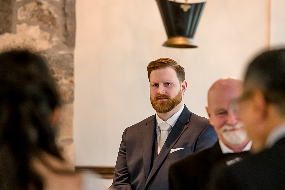 groom photo while bride walks down the aisle in chapel