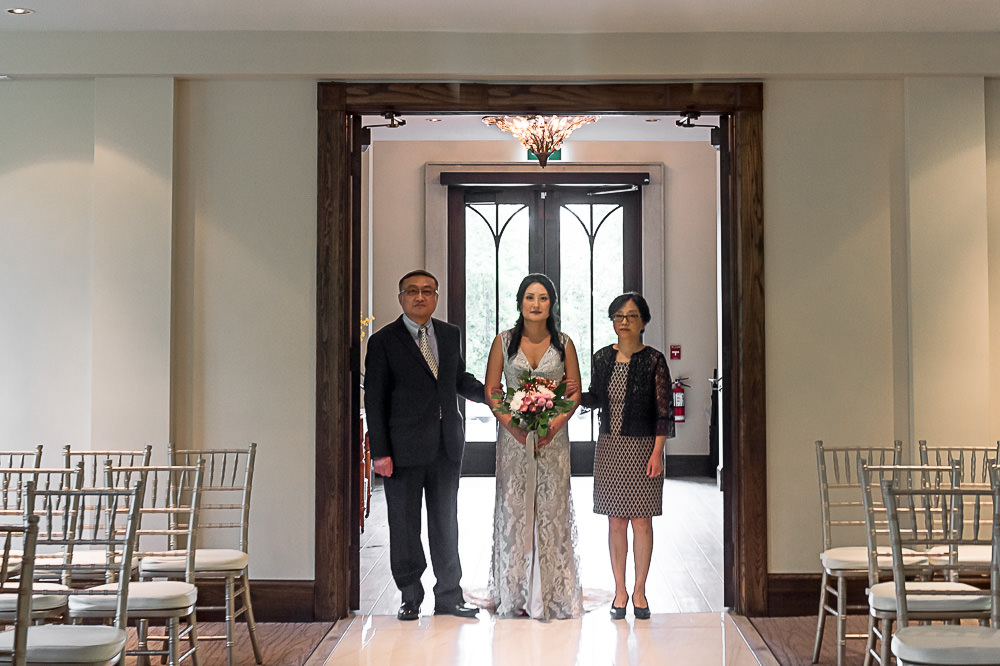 bride walking down the aisle with mother and father