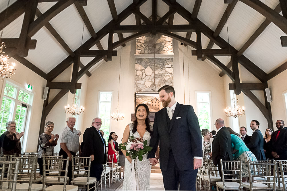 bride and groom walk down the aisle together after ceremony