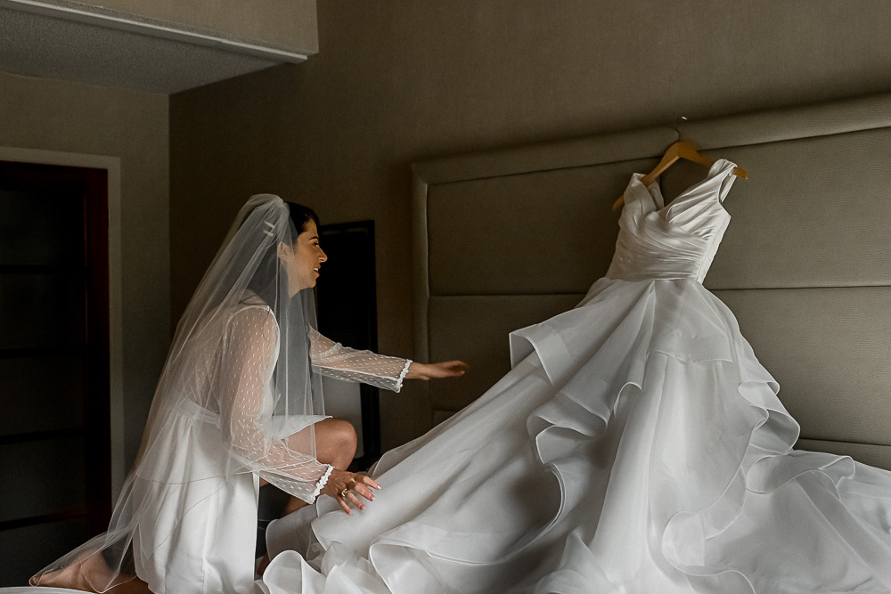 bride reaching for dress
