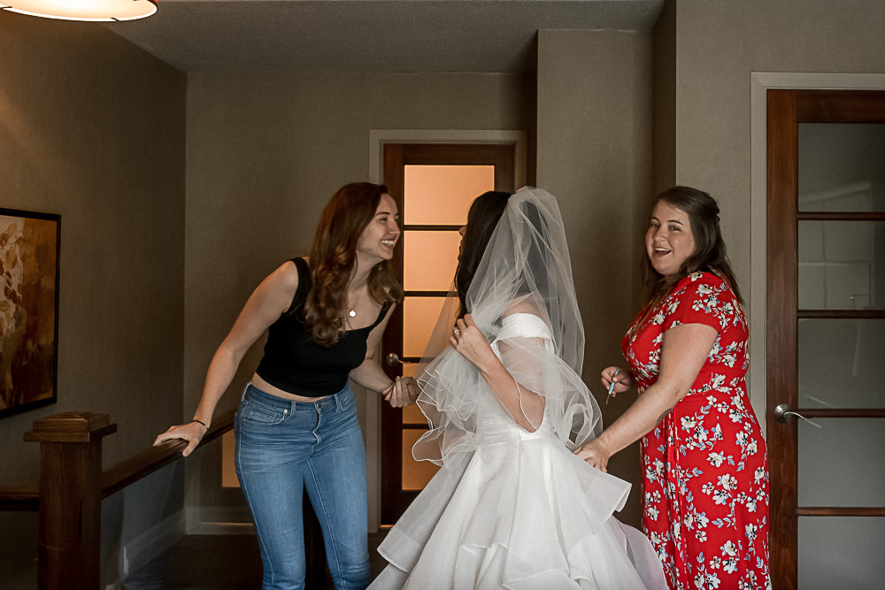 bride getting dressed with friends