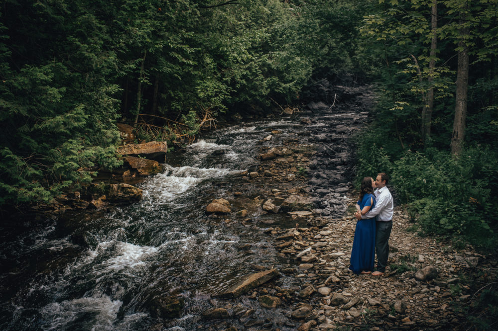 Girl in blue dress in creek with groom