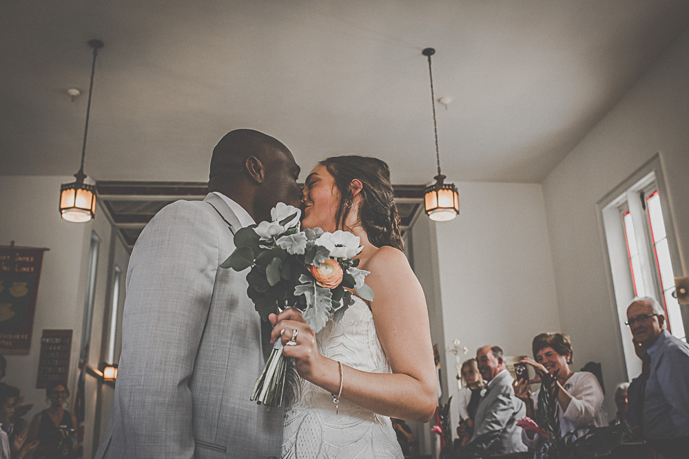 bride and groom kissing in chapel
