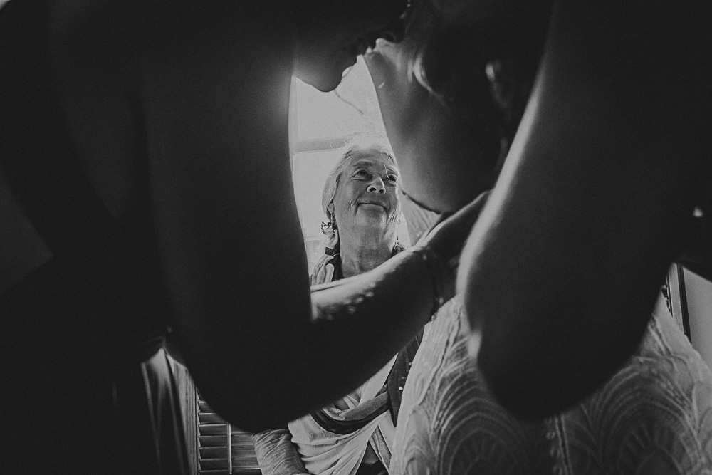 mother looking at bride getting ready