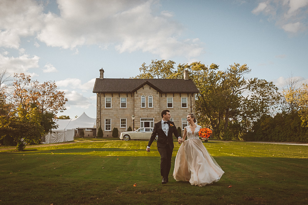 bride groom running on front lawn of estate