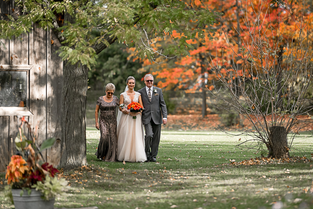 bride coming down the aisle with mom and dad