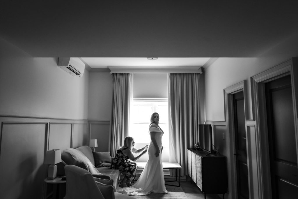 mother doing up brides dress at dorchester hotel