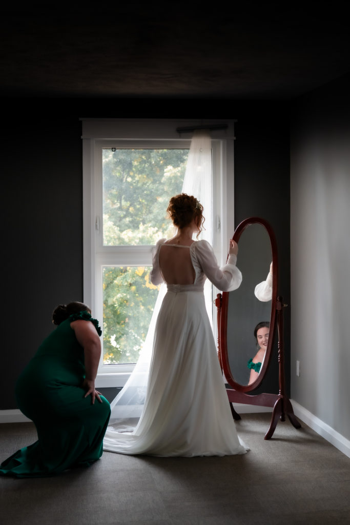moms reflection in mirror while helping daughter