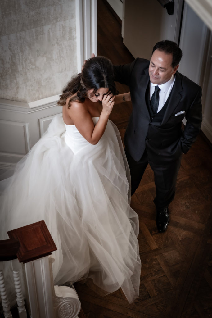 bride walking down stairs to dad
