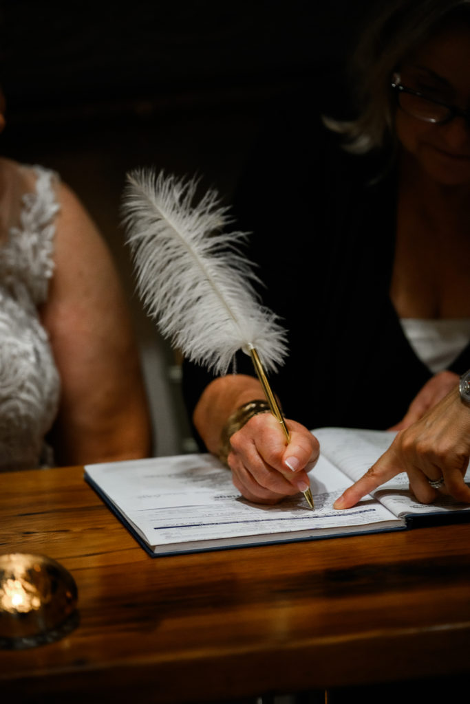 signing the marriage license photo with feather pen